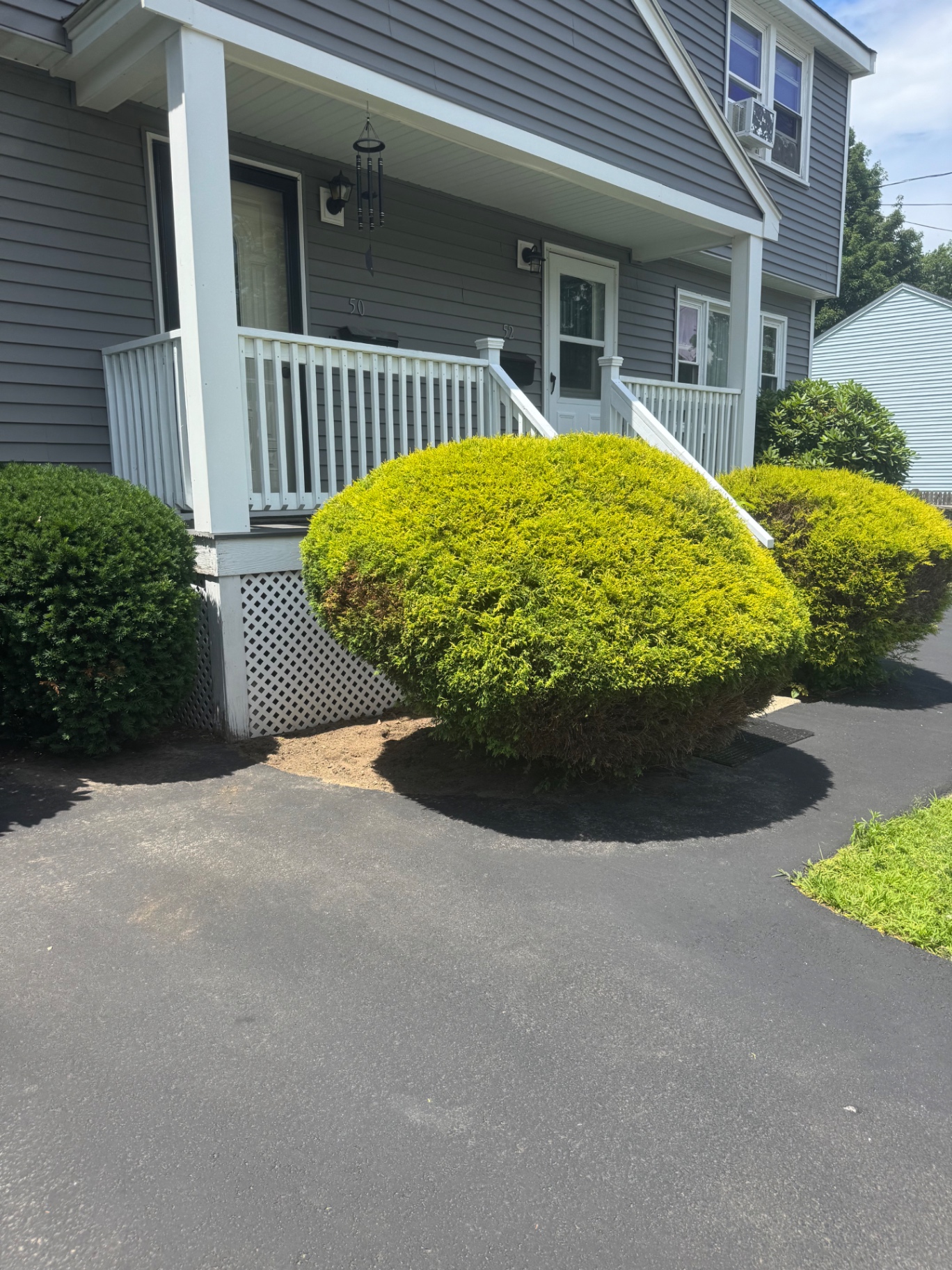 Shaped shrubs and manicured landscape beds along the front of a home